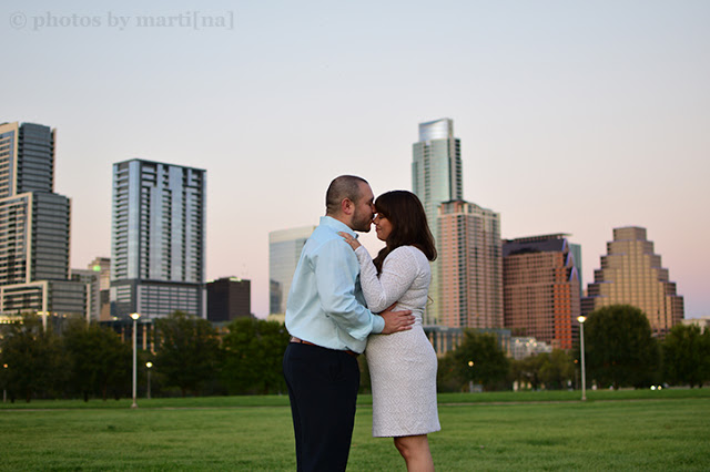 Engaged couple standing in front of downtown Austin, Texas. 