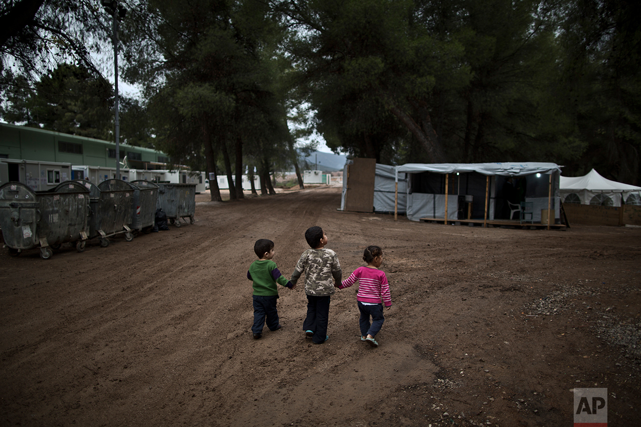 Syrian refugee children hold hands while walking in the refugee camp of Ritsona about 86 kilometers (53 miles) north of Athens, Wednesday, Dec. 28, 2016.  (AP Photo/Muhammed Muheisen)