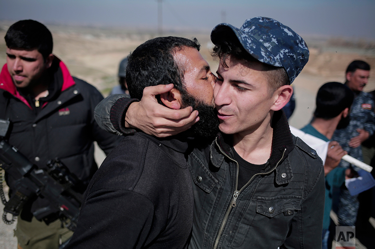 A civilian kisses a federal police officer after escaping Islamic State territory in the town of Abu Saif, Tuesday, Feb. 21, 2017. Iraqi forces advanced into the southern outskirts of Mosul in a push to drive Islamic State militants from the city's western half, as the visiting U.S. defense secretary met with officials to discuss the fight against the extremists.(AP Photo/Bram Janssen)
