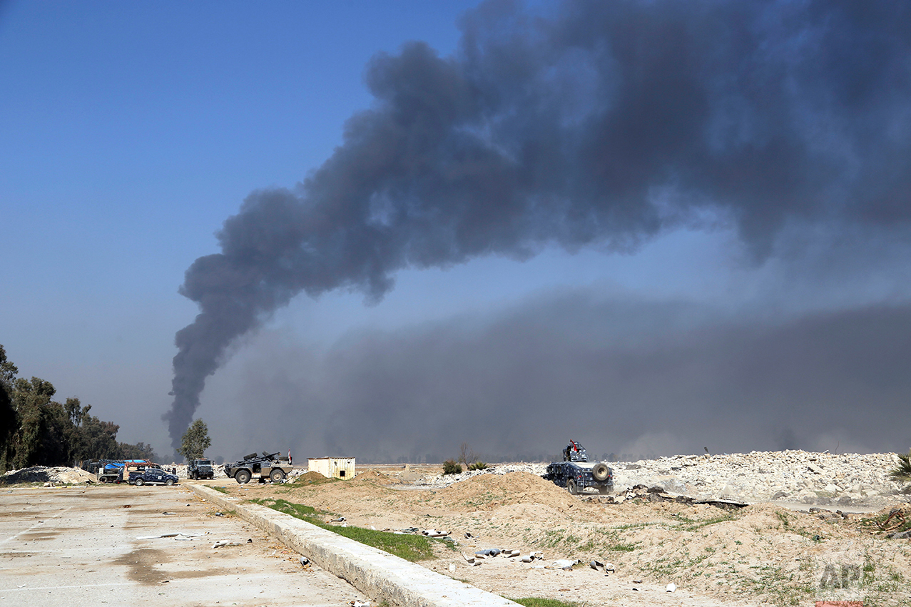 Smoke rises Iraqi security forces deploy inside Mosul's international airport, Iraq, Feb. 24. 2017. (AP Photo/ Khalid Mohammed)