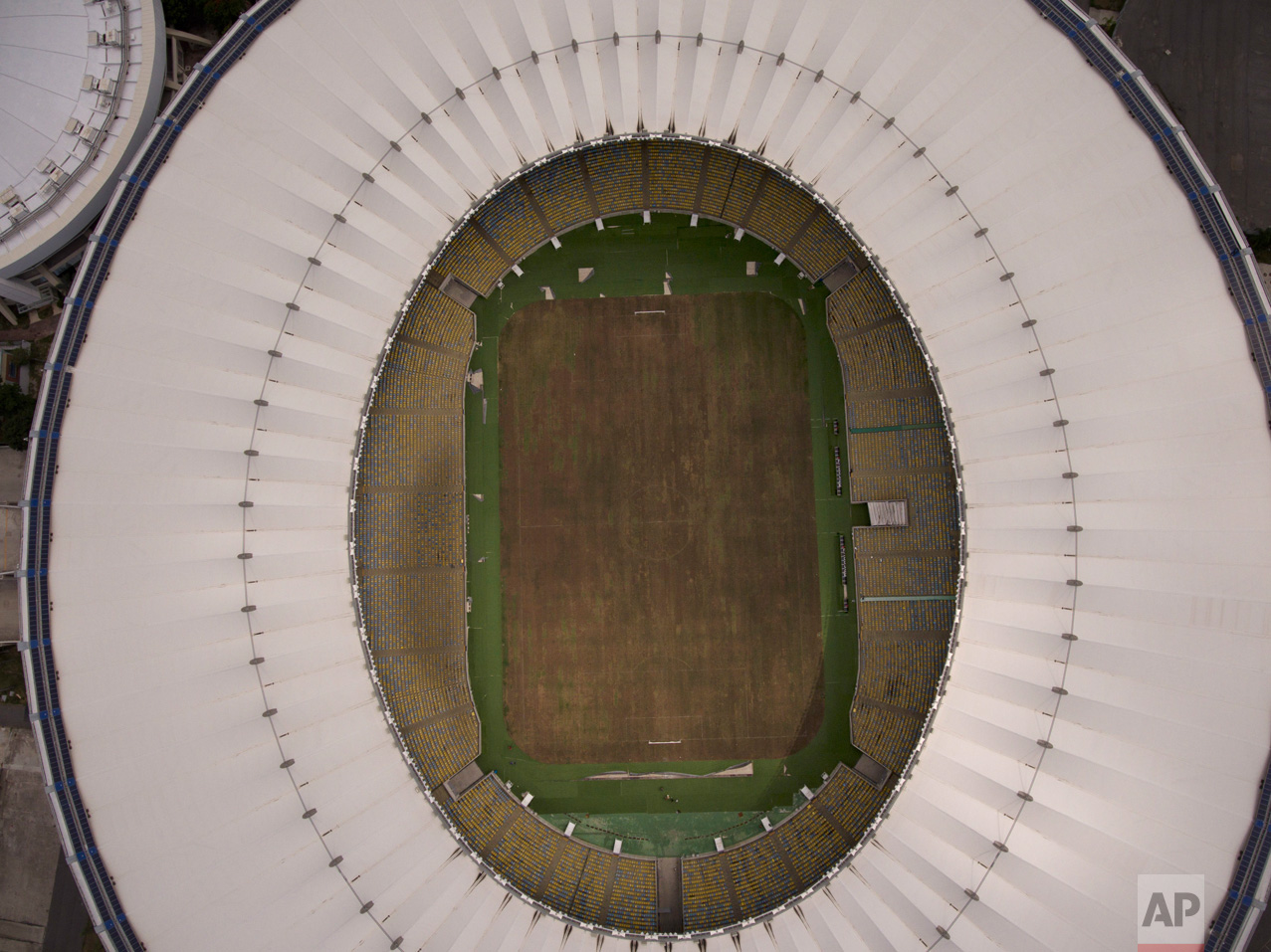 This Feb. 2, 2017 photo shows Maracana stadium's dry playing field in Rio de Janeiro, Brazil. The stadium was renovated for the 2014 World Cup at a cost of about $500 million, and largely abandoned after the Olympics and Paralympics, then hit by vandals who ripped out thousands of seats and stole televisions. (AP Photo/Mario Lobao)