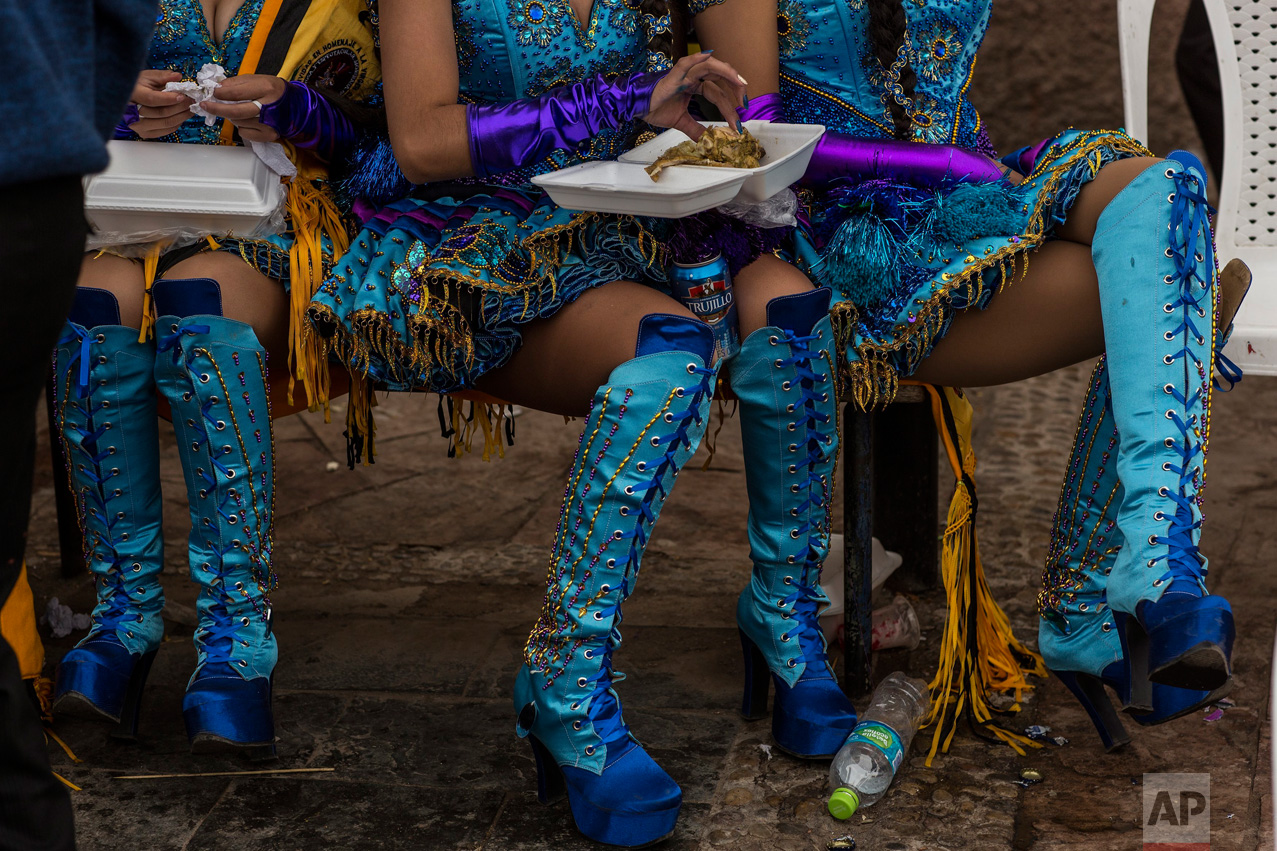 Dancers eat lunch during a break from performing at the Virgin of Candelaria celebrations in Puno, Peru, Sunday, Feb. 5, 2017. (AP Photo/Rodrigo Abd)