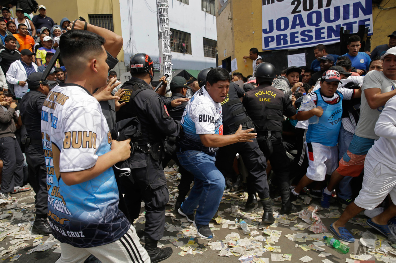  In this Monday, May 1, 2017 photo, soccer fans force themselves past police during an interval between games at the Little World Cup of Provenir street soccer championship in Lima, Peru. Dozens of teams bring their fans to defend each goal, even if it comes to blows, so anti-riot police line the pitch. (AP Photo/Martin Mejia) 