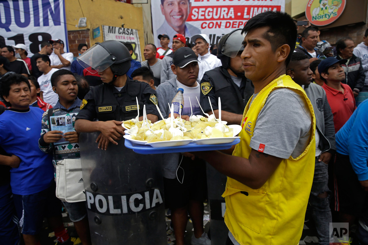  In this Monday, May 1, 2017, a food vendor works the crowd during a break at the Little World Cup of Provenir street soccer championship in Lima, Peru. His tray is filled with plates of baked potatoes, boiled eggs and a spicy cream. (AP Photo/Martin Mejia) 
