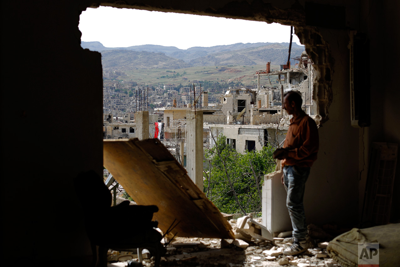 A man surveys damage at the mountain resort town of Zabadani in the Damascus countryside, Syria, on Thursday, May 18, 2017. An estimated 400,000 have been killed and half the population displaced by the 6-year-old civil war. (AP Photo/Hassan Ammar)