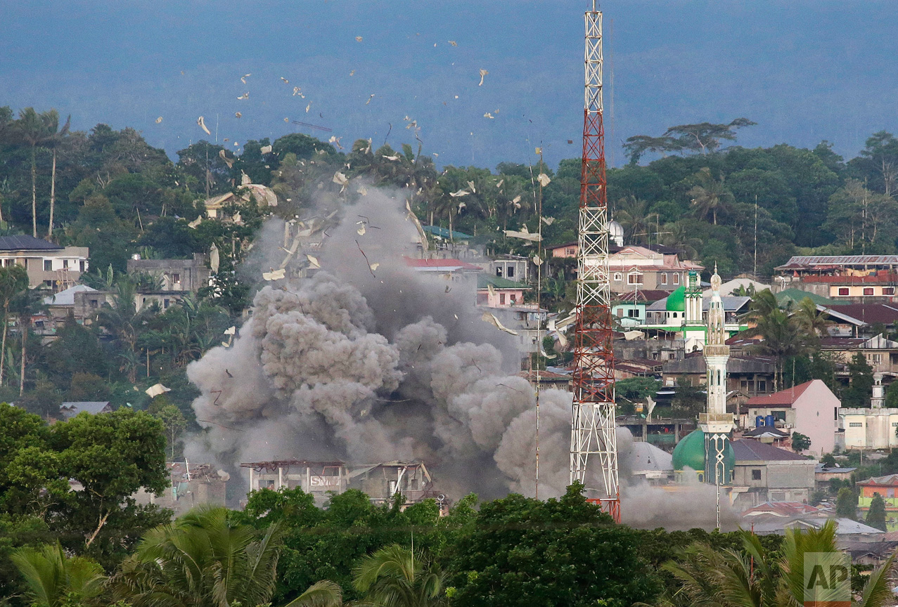 Debris flies in the air as Philippine Air Force fighter jets bomb suspected locations of Muslim militants as fighting continues in Marawi city, southern Philippines Friday, June 9, 2017. It's unclear how many people remain trapped in Marawi as government troops battle Muslim militants led by the "Maute" group, but army officers have put the figure this week at anywhere from 150 to 1,000. (AP Photo/Aaron Favila)