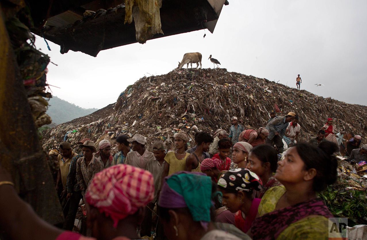 Indian "ragpickers" wait to collect recyclable materials as a truck prepares to unload garbage at a dump on the outskirts of Gauhati, Assam state, India, Monday, June 5, 2017. Monday marks World Environment Day. (AP Photo/Anupam Nath)