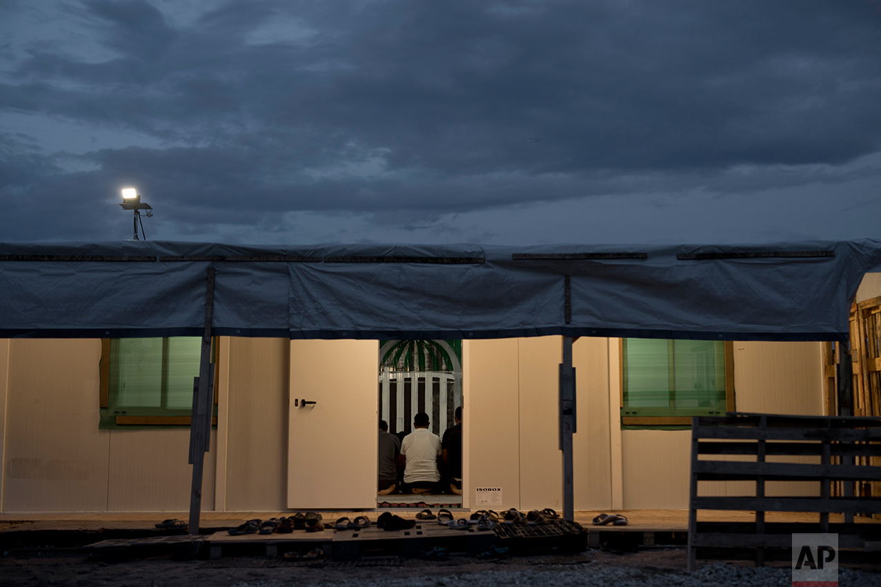 In this May 25, 2017 photo, refugees and other migrants pray inside a tent at the refugee camp of Ritsona about 86 kilometers (53 miles) north of Athens. This trailer is being used as a mosque in the camp. (AP Photo/Petros Giannakouris)