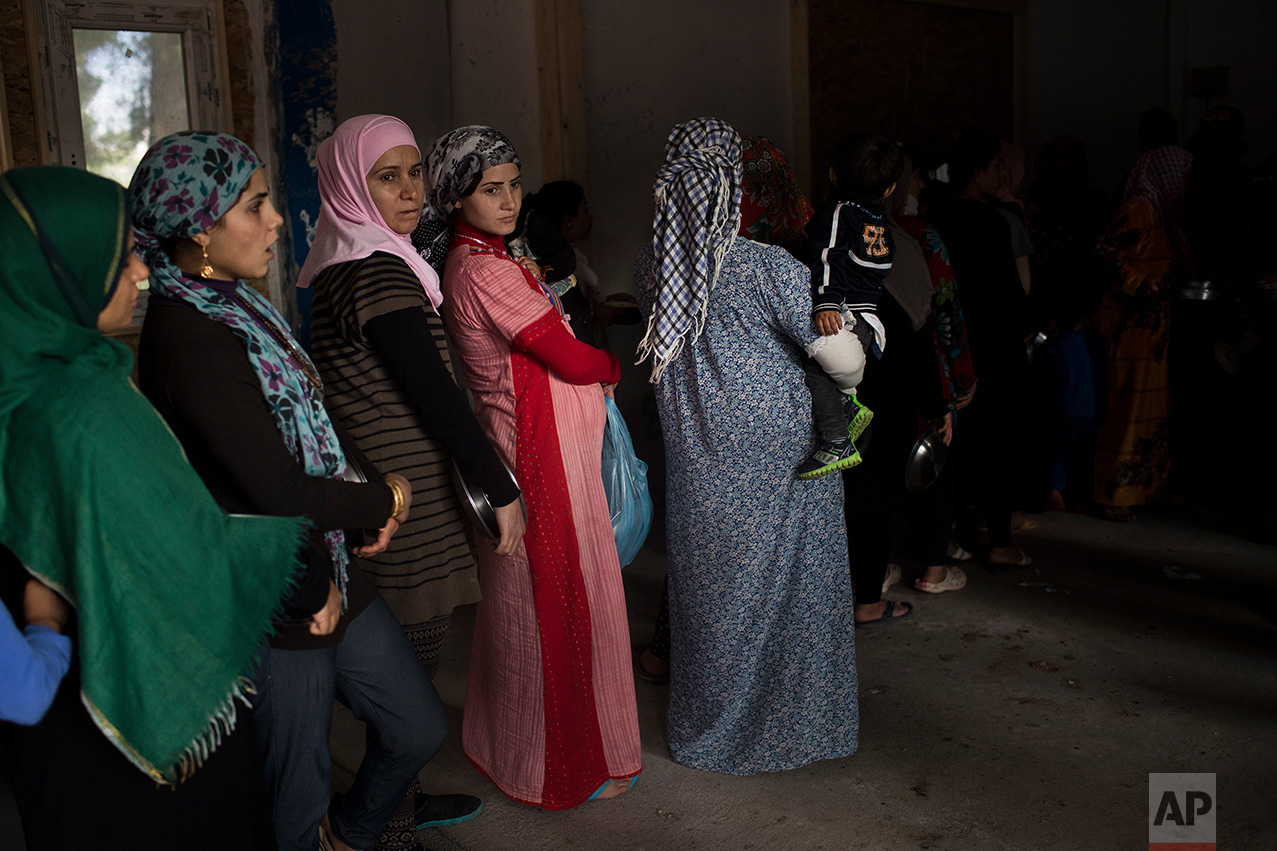 In this May 29, 2017, photo Syrian women queue for food distribution at the refugee camp of Ritsona about 86 kilometers (53 miles) north of Athens. (AP Photo/Petros Giannakouris)