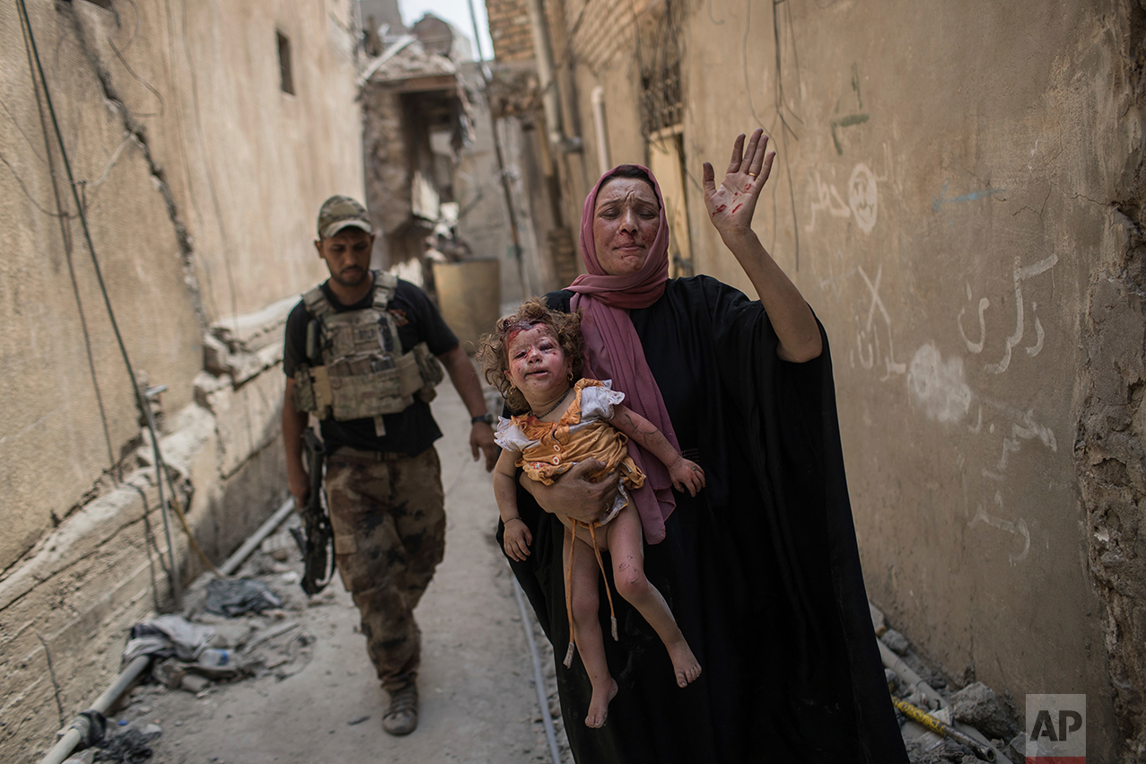 A woman holds a young injured girl as Iraqi forces continue their advance against Islamic State militants in the Old City of Mosul, Iraq, Monday, July 3, 2017. (AP Photo/Felipe Dana)