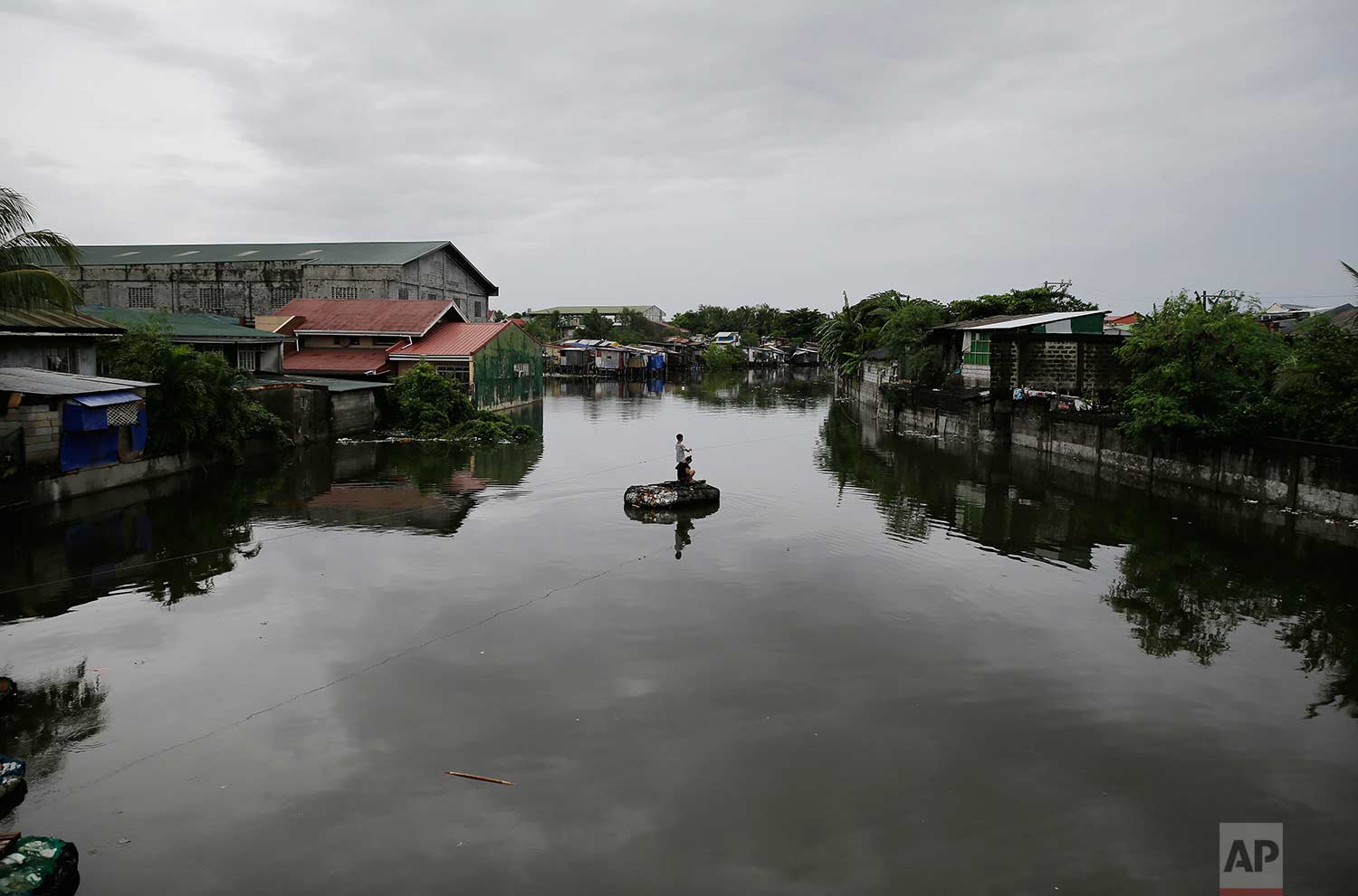 Residents pull a rope in an improvised raft to cross a swollen river caused by tropical storm Gorio on the outskirts of Manila, Philippines on Wednesday, July 26, 2017. (AP Photo/Aaron Favila)