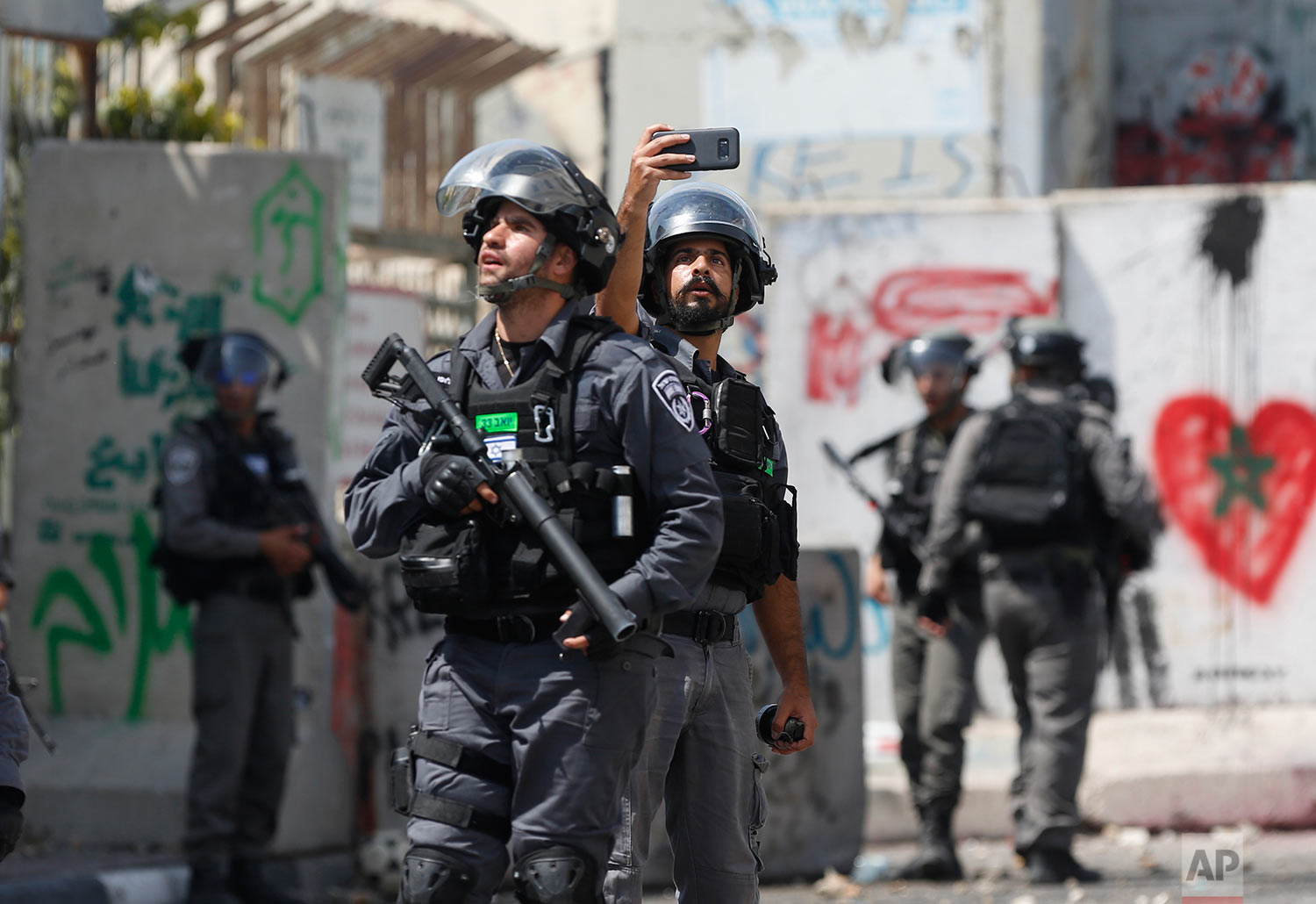 An Israeli border policeman takes a selfie during clashes in the West Bank city of Bethlehem, Friday, July 21, 2017. (AP Photo/Nasser Shiyoukhi)