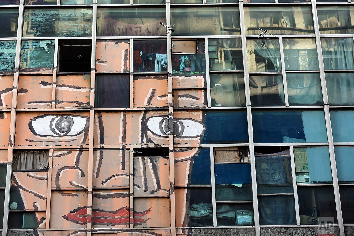 In this June 24, 2017 photo, a girl looks out from her window at the former Federal Police headquarters building in downtown  Sao Paulo, Brazil. (AP Photo/Andre Penner)