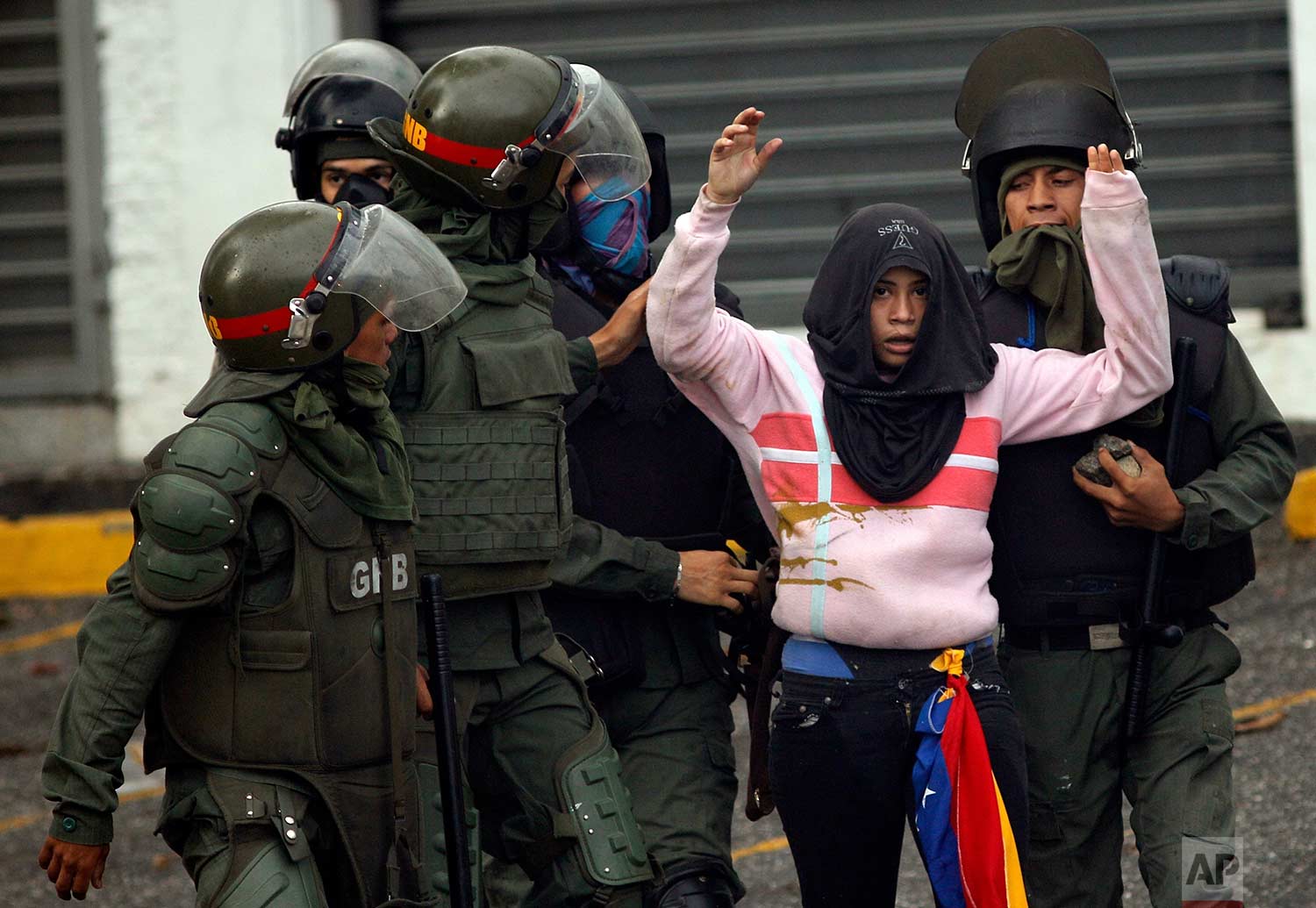 Bolivarian National Guards detain an anti-government demonstrator during clashes in Caracas, Venezuela, Friday, July 28, 2017, two days before the vote to begin the rewriting of Venezuela's constitution. (AP Photo/Ariana Cubillos)