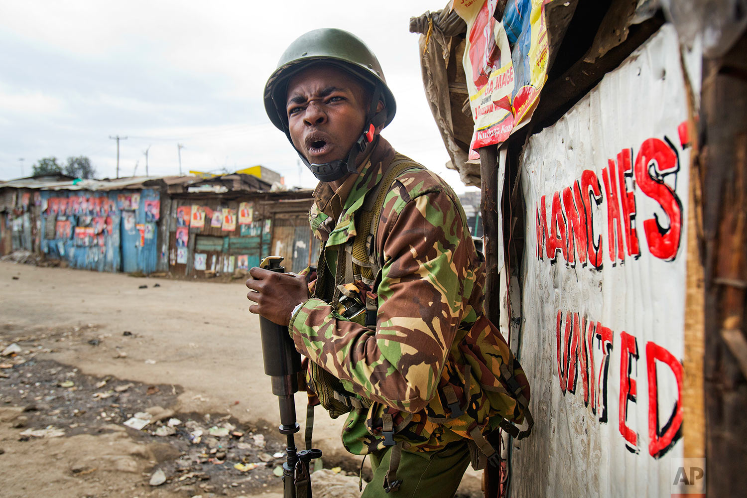  A Kenyan security forces officer shouts before firing a tear gas canister to chase supporters of Kenyan opposition leader and presidential candidate Raila Odinga, who demonstrated in the Mathare area of Nairobi, Wednesday, Aug. 9, 2017. Odinga alleges that hackers manipulated the Tuesday election results which appear to show President Uhuru Kenyatta has a wide lead over Odinga. (AP Photo/Jerome Delay) 