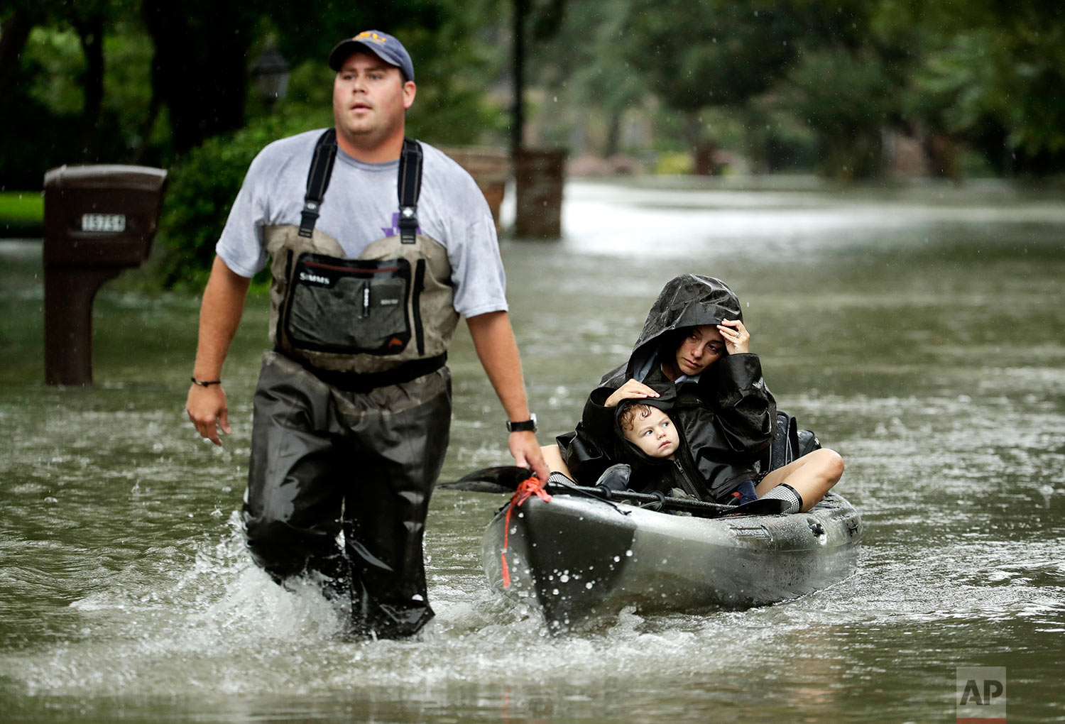 People evacuate a neighborhood inundated by floodwaters from Tropical Storm Harvey on Monday, Aug. 28, 2017, in Houston, Texas. (AP Photo/Charlie Riedel)