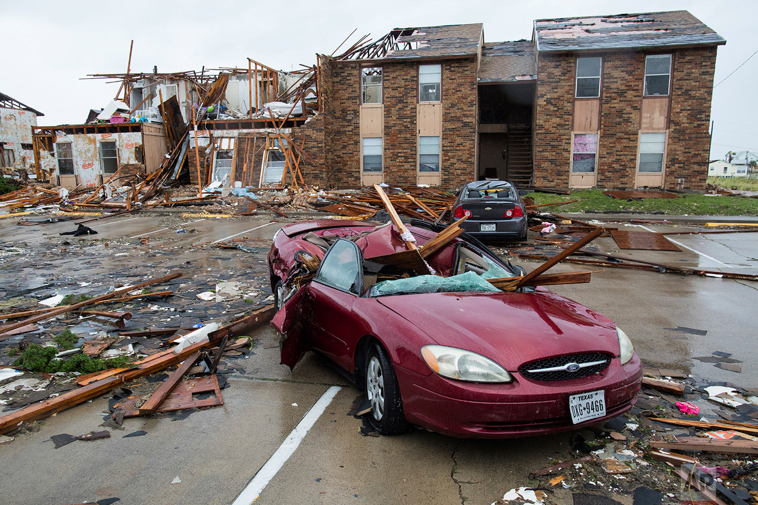 A damaged car sits outside a heavily damaged apartment complex in Rockport, Texas, after Hurricane Harvey struck the area, Saturday, Aug. 26, 2017. (Courtney Sacco/Corpus Christi Caller-Times via AP)