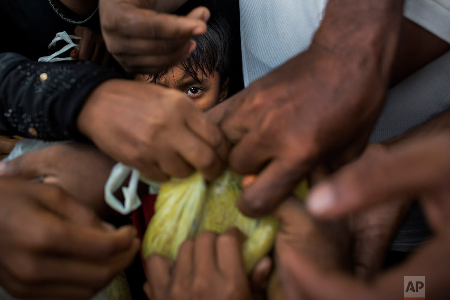 Newly arrived Myanmar's Rohingya ethnic minority refugees scuffle for food rations near Kutupalong refugee camp in Ukhia, Bangladesh, Sunday, Sept. 3, 2017. (AP Photo/Bernat Armangue)