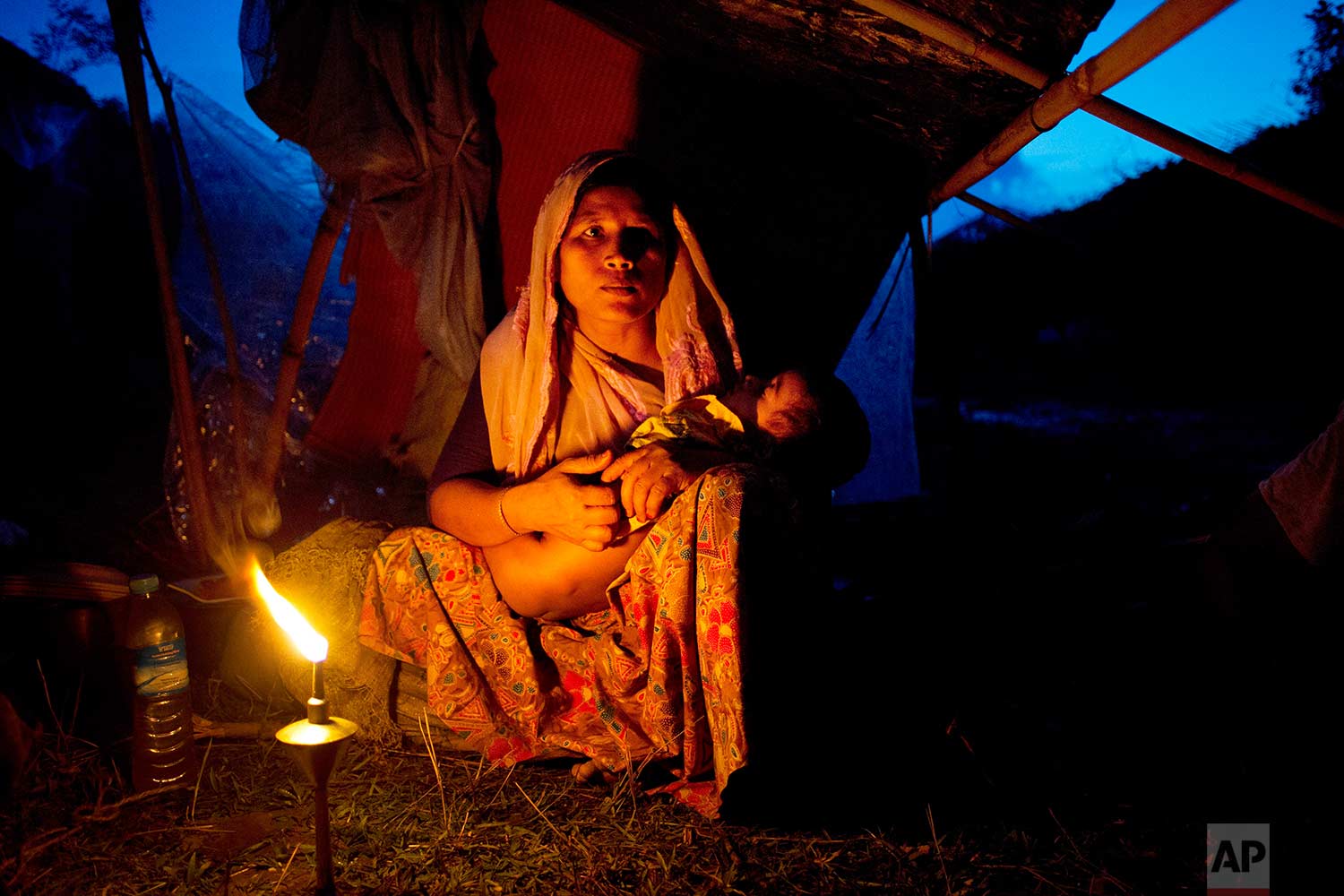  A Rohingya ethnic minority woman cradles her child at a temporary makeshift camp after crossing over from Myanmar into the Bangladesh side of the border, near Cox's Bazar's Gundum area, Saturday, Sept. 2, 2017. U.N. spokesman Stephane Dujarric told reporters at U.N. headquarters on Friday that while many of the 270,000 Rohingyas who have fled violence in Rakhine state in the past two weeks initially arrived in Bangladesh by land, more are now making the journey by boat. (AP Photo/Bernat Armangue) 