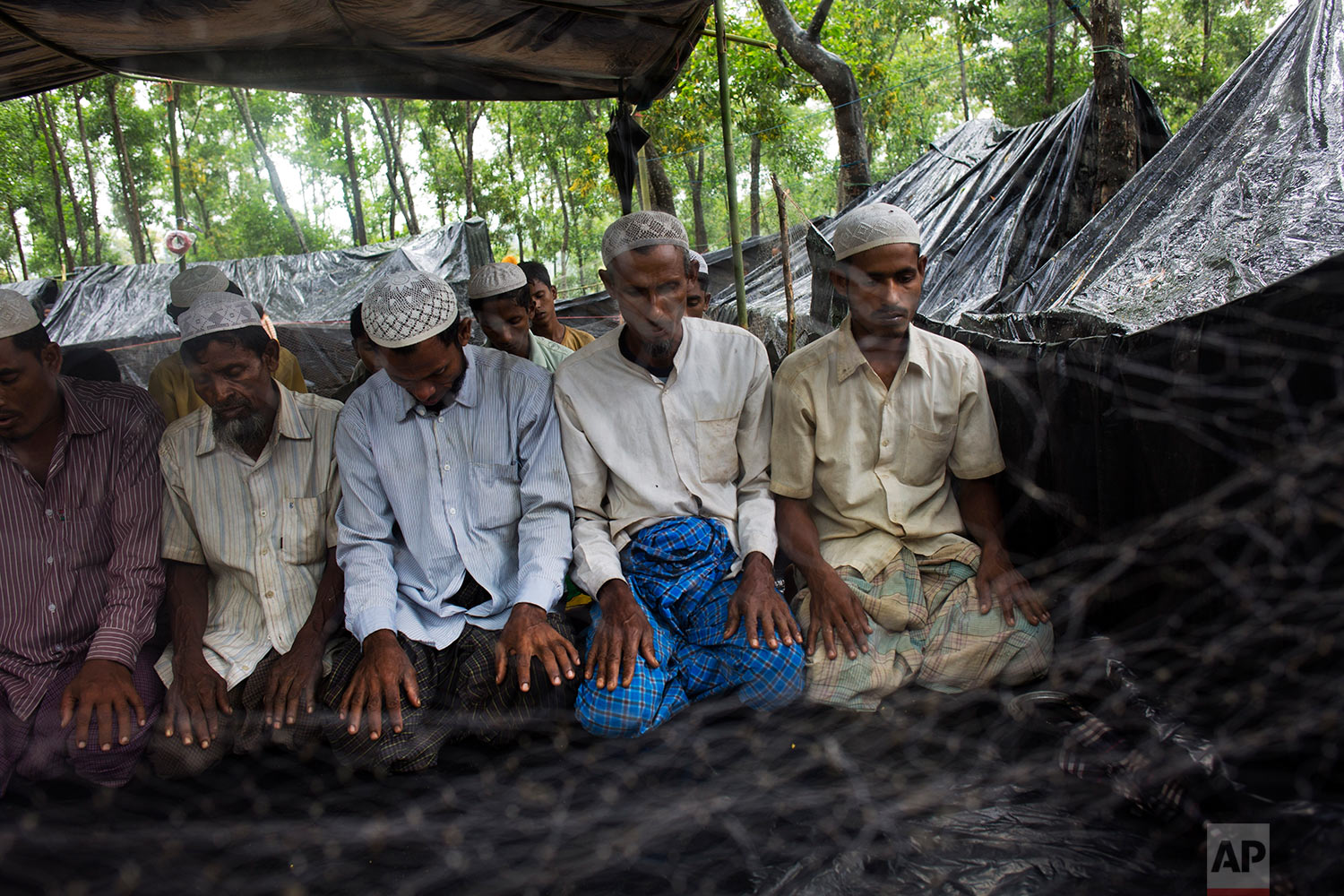 Rohingya Muslims, who have recently crossed over the border from Myanmar into Bangladesh, offer Friday prayers at a makeshift mosque in Kutupalong, Bangladesh, Friday, Sept. 8, 2017. (AP Photo/Bernat Armangue)