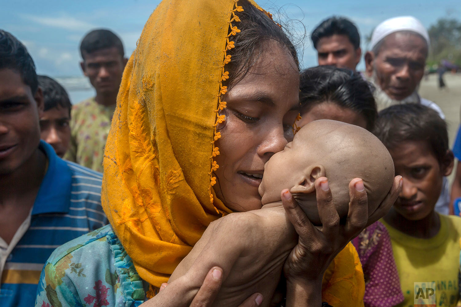 A Rohingya Muslim woman Hanida Begum, who crossed over from Myanmar into Bangladesh, kisses her infant son Abdul Masood who died when the boat they were traveling in capsized just before reaching the shore of the Bay of Bengal, in Shah Porir Dwip, Bangladesh, Thursday, Sept. 14, 2017. (AP Photo/Dar Yasin)