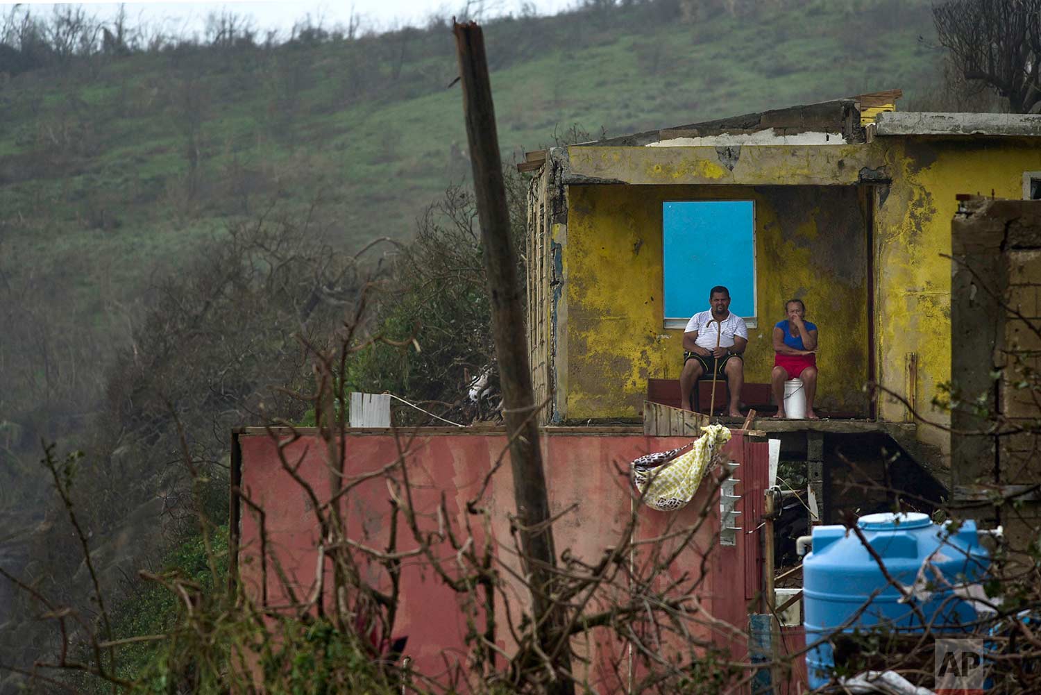 A couple sits in their home in El Negro, Puerto Rico on Thursday, Sept. 21, 2017, a day after the impact of Hurricane Maria. A day after Maria ravaged Puerto Rico, flooding towns, crushing homes and killing at least two people, millions of people on the island faced the dispiriting prospect of weeks and perhaps months without electricity. (AP Photo/Carlos Giusti)