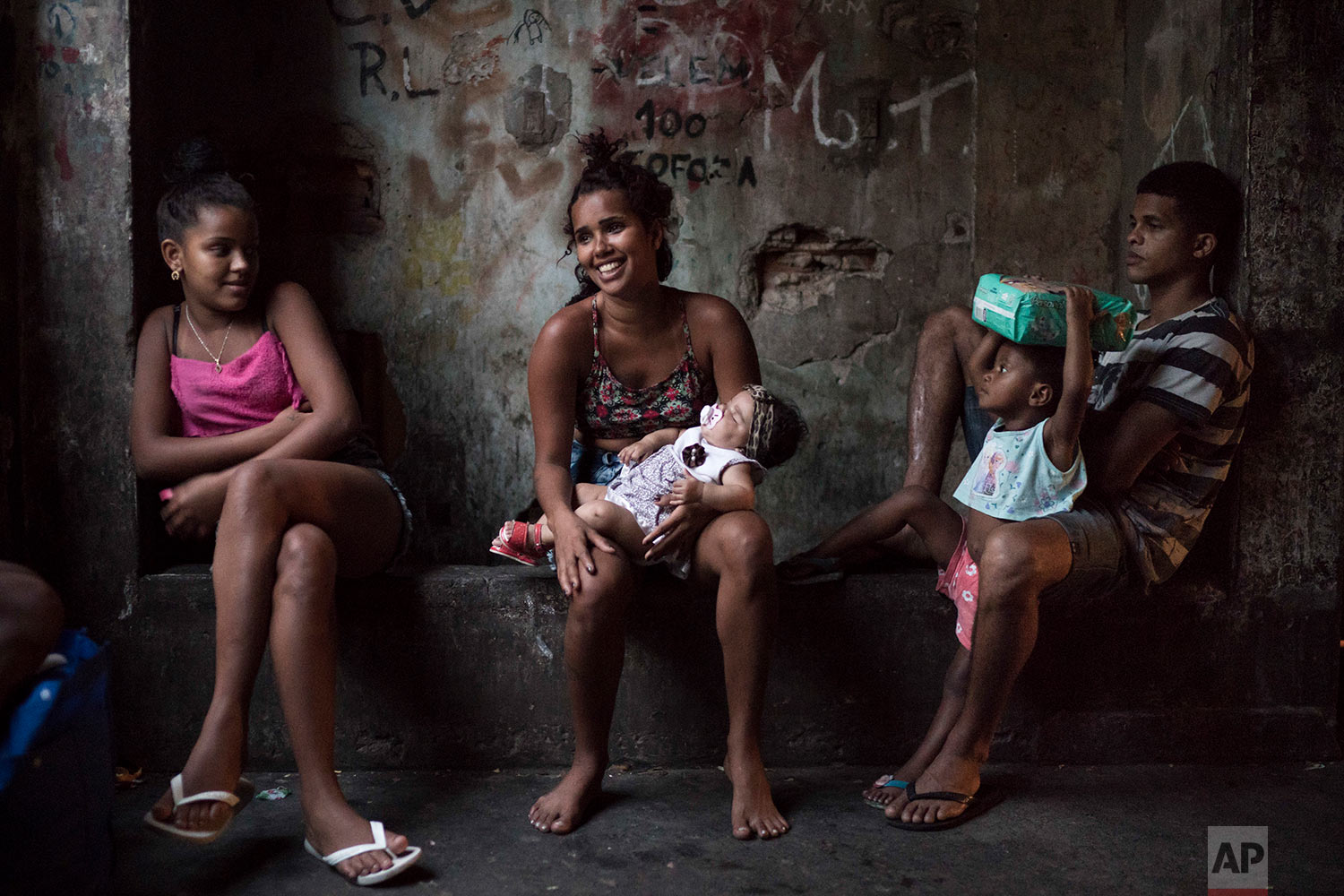  In this Sept. 9, 2017 photo, residents sit in a corridor inside a squatter building that used to house the Brazilian Institute of Geography and Statistics (IBGE) in the Mangueira slum of Rio de Janeiro, Brazil. Despite the hardscrabble existence, there is a strong sense of community among the hundreds of people occupying the building. (AP Photo/Felipe Dana) 