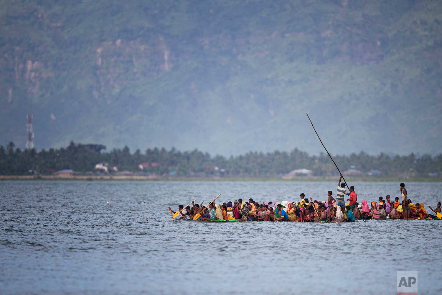  Rohingya Muslims aboard a makeshift raft made with plastic containers cross the Naf River from Myanmar into Bangladesh, near Shah Porir Dwip, Bangladesh, Sunday, Nov. 12, 2017. (AP Photo/A.M. Ahad) 