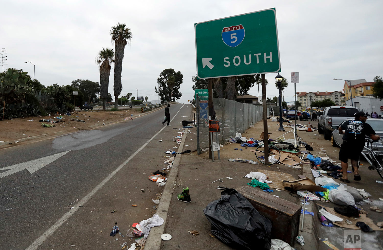  In this Sept. 19, 2017 photo, trash from homeless encampments lines an entrance ramp for Interstate Highway 5 in San Diego. In a place that bills itself as “America’s Finest City,” renowned for its sunny weather, surfing and fish tacos, spiraling real estate values have contributed to spiraling homelessness in San Diego. Most alarmingly, the explosive growth in the number of people living outdoors has contributed to a hepatitis A epidemic. (AP Photo/Gregory Bull) 