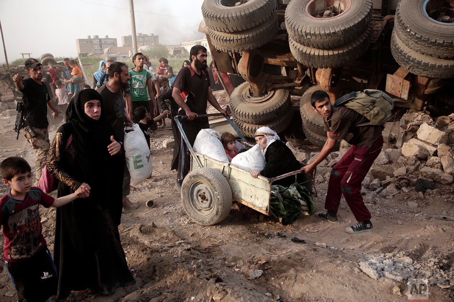  An elderly woman and a child are pulled on a cart as civilians flee heavy fighting between Islamic State militants and Iraqi special forces in western Mosul, Iraq on Wednesday, May 10, 2017. (AP Photo/Maya Alleruzzo) 