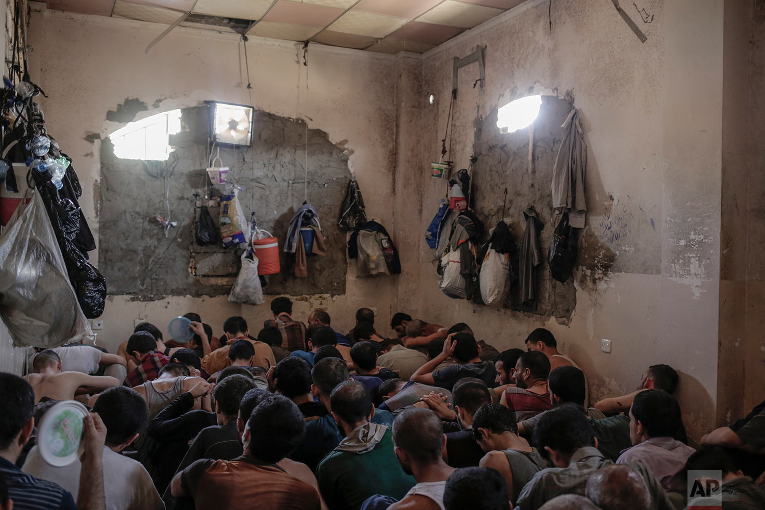  More than 100 Islamic State suspects sit inside a small room in a prison south of Mosul, Tuesday, July 18, 2017. A total of more 370 IS suspects are being held in bad conditions in the prison. (AP Photo/Bram Janssen) 