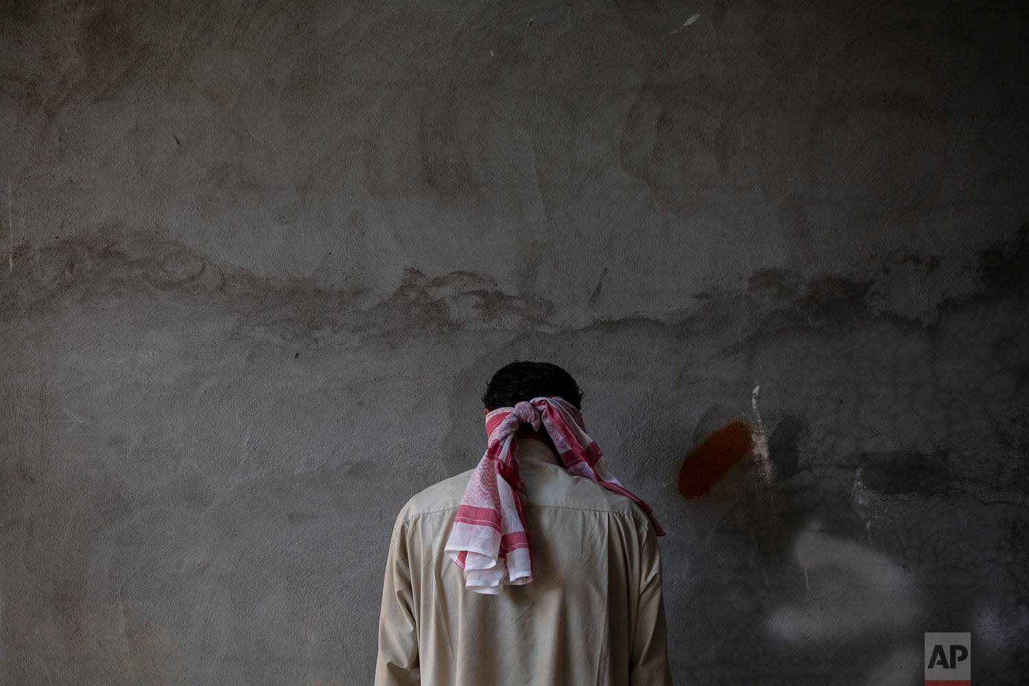  A blindfolded Islamic State suspect stands against a wall at a Kurdish screening center in Dibis, Tuesday, Oct. 3, 2017. Displaced people from Hawija are brought to the center where men are being separated from the women and children and are investigated for involvement in the Islamic State group. (AP Photo/Bram Janssen) 