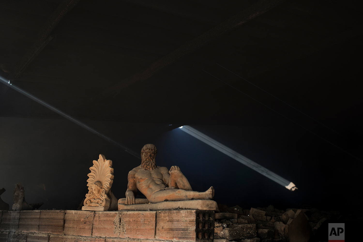  In this Friday, Nov. 20, 2017 photo, a sooty, dust-covered terracotta statue of Greek mythological hero Hercules, a son of Zeus, stands on top of a burning furnace next to an antefix in Haralambos Goumas' sculpture and ceramic workshop, in the Egaleo suburb of Athens. (AP Photo/Petros Giannakouris) 