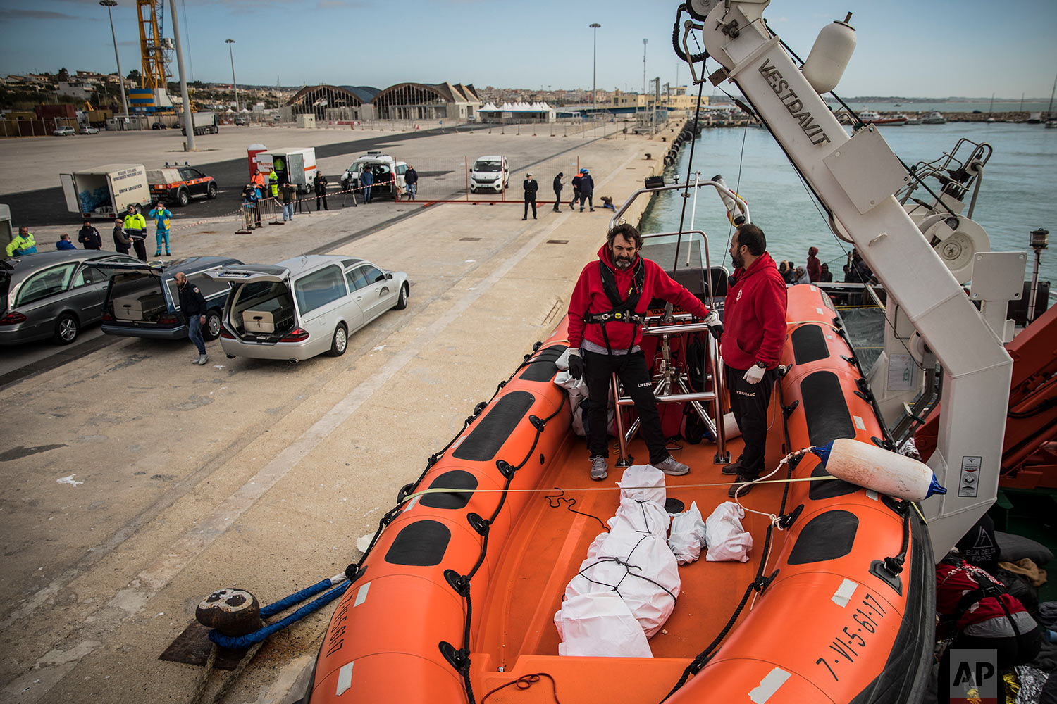  In this Friday, Jan. 19, 2018 photo aid workers from the Spanish NGO Proactiva Open Arms wait to disembark the lifeless bodies of an Eritrean man and 2 babies from the organization's rescue vessel, at the port of Pozzallo, in Sicily, Italy. (AP Photo/Santi Palacios)&nbsp; |&nbsp; See these photos on AP Images  