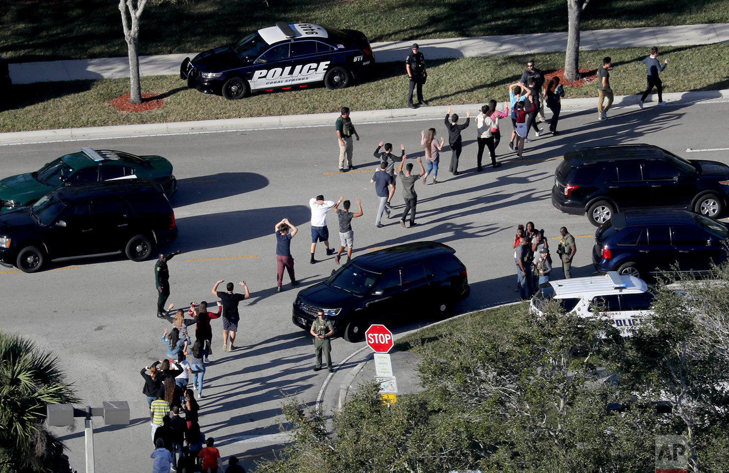  Students hold their hands in the air as they are evacuated by police from Marjory Stoneman Douglas High School in Parkland, Fla., on Wednesday, Feb. 14, 2018, after a shooter opened fire on the campus. (Mike Stocker/South Florida Sun-Sentinel via AP) 