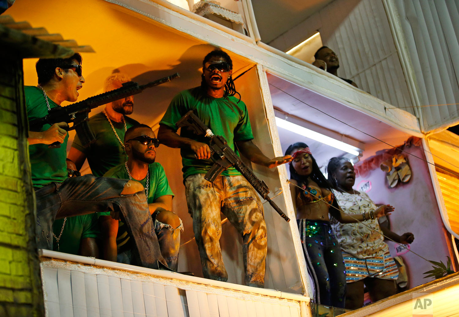  Members from the Beija Flor samba school portray drug traffickers during Carnival celebrations at the Sambadrome in Rio de Janeiro, Brazil, early Tuesday, Feb. 13, 2018. Brazil's most famous city has long struggled with violence, particularly in the hundreds of slums controlled by drug traffickers, with criminal assaults and increasing shootouts between drug traffickers and police. (AP Photo/Silvia Izquierdo) 