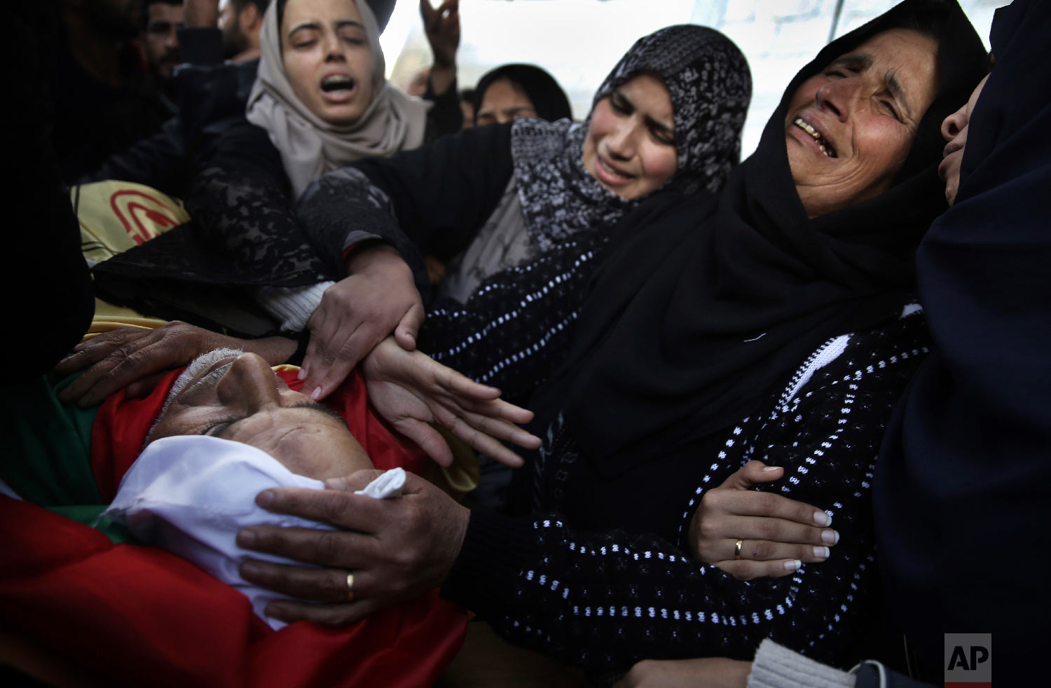  Relatives of Palestinian 59-year-old farmer, Muhammed Abu Jamaa, mourn over his body in the family house during his funeral in town of Khan Younis, southern Gaza Strip, Sunday, March 4, 2018. (AP Photo/ Khalil Hamra) 
