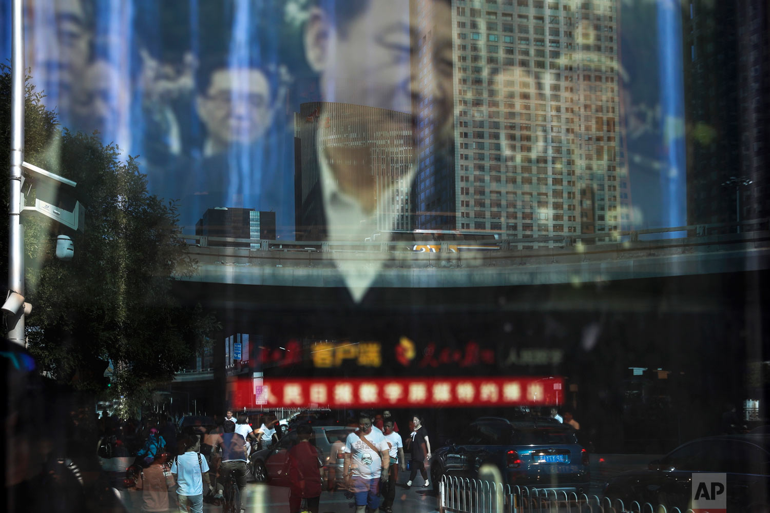  In this Wednesday, May 30, 2018, photo, people and motorists in morning rush hour are reflected on an electronic display panel advertising a video footage of Chinese President Xi Jinping near the Central Business District in Beijing. Chinese factory activity grew at its fastest rate in eight months on stronger demand, a survey showed Thursday, May 31, 2018 in a positive sign for the world's No. 2 economy despite trade tensions with the U.S. China's services industry is playing a bigger role as communist leaders upgrade economic growth, shifting it from a worn-out model based on wasteful trade and investment to one focused on domestic spending. (AP Photo/Andy Wong) 
