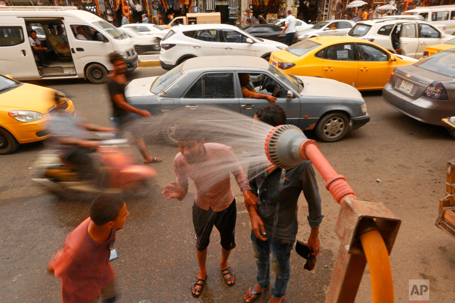  People cool off from the summer heat under an open air shower in Baghdad, Iraq, Wednesday, May 30, 2018. The temperature in Baghdad reached 109 F (42 C) on Wednesday. (AP Photo/Hadi Mizban) 