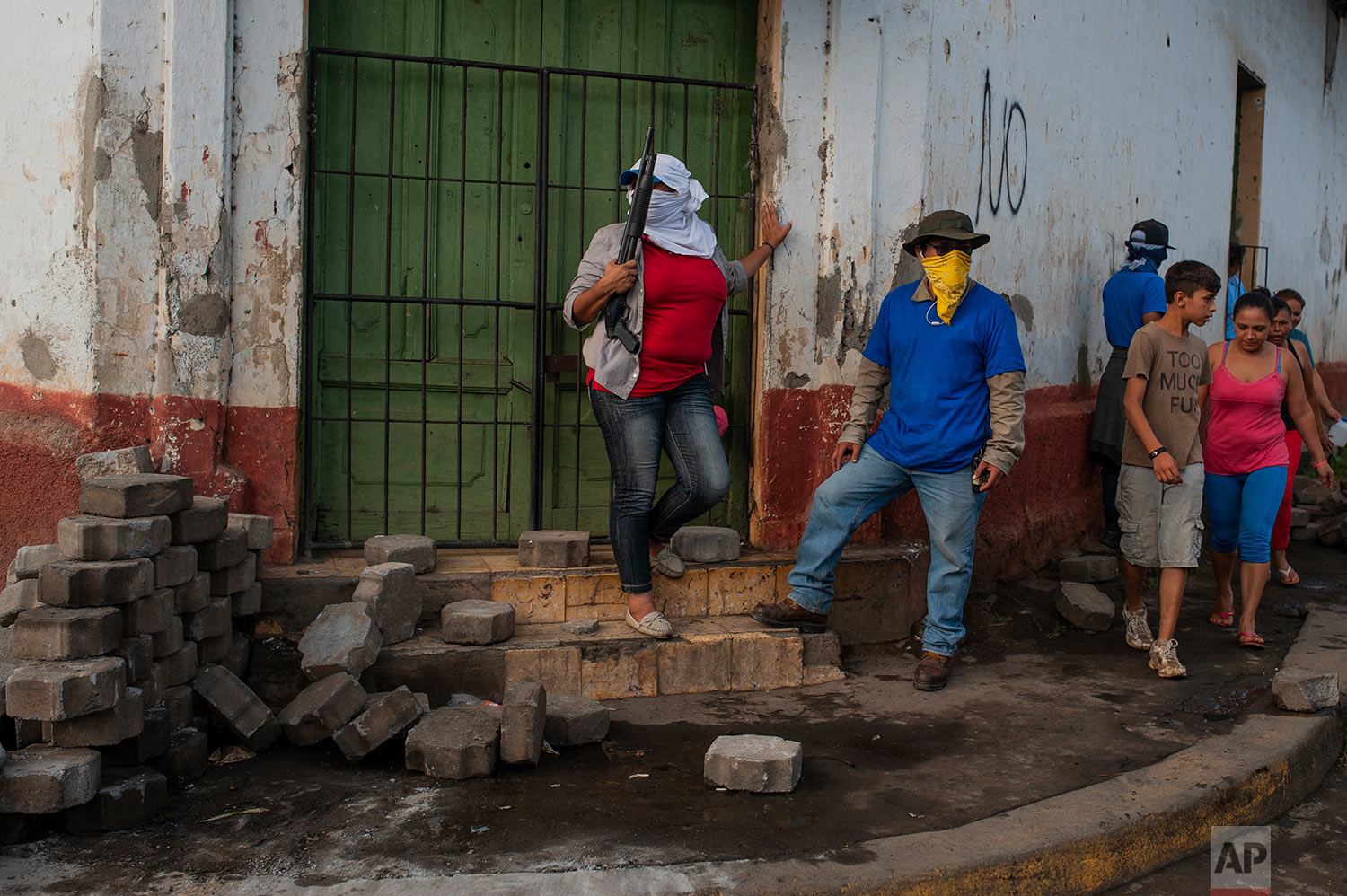  Pro-government Sandinista militia members stand guard at a torn down barricade, which had been set up by anti-government protesters, after police and militias stormed the Monimbo neighborhood of Masaya, Nicaragua, July 17, 2018. Heavily armed police and militias laid siege to and then retook a symbolically important neighborhood that had recently become a center of resistance to President Daniel Ortega's government. (AP Photo/Cristobal Venegas) 