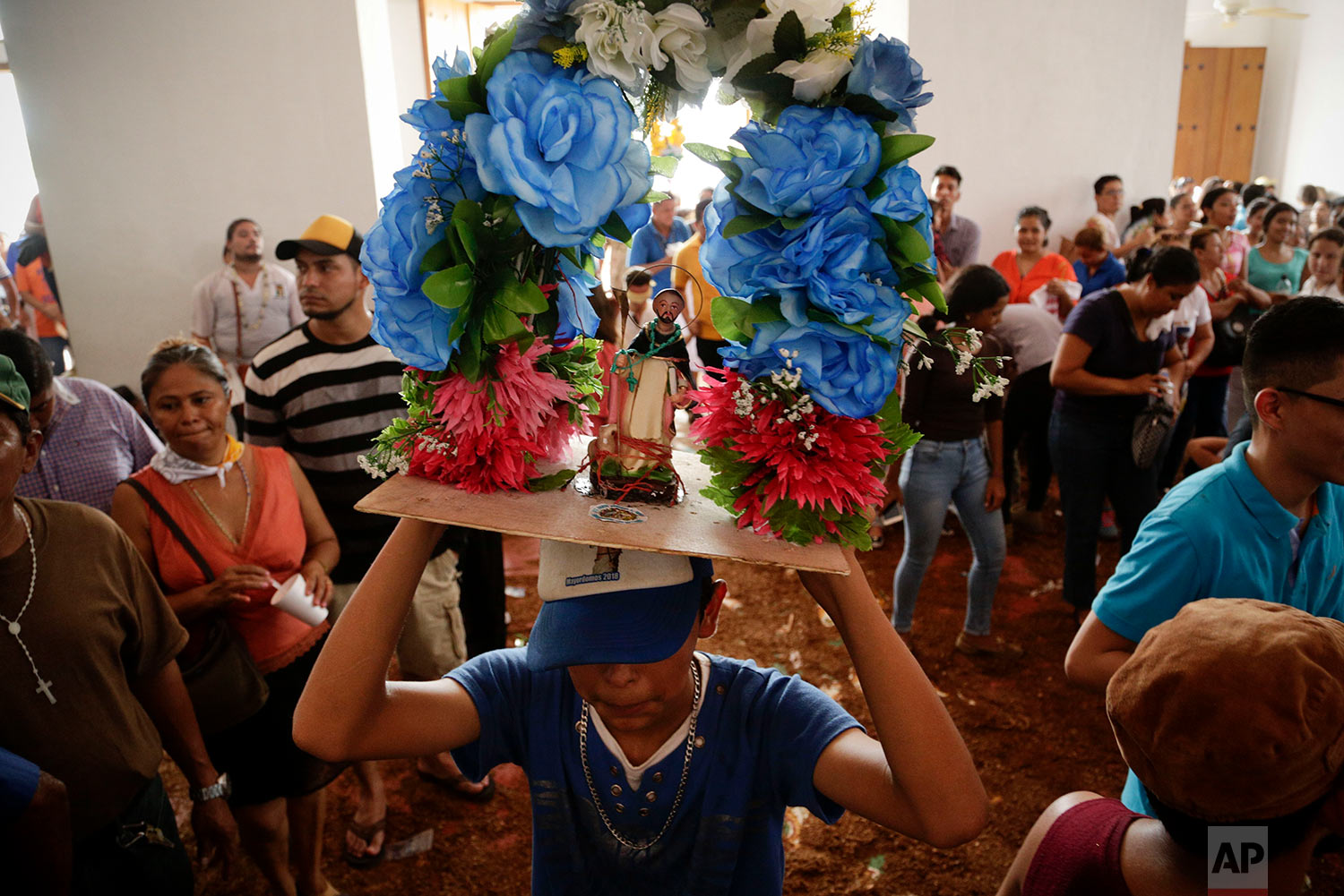  A youth holds up a statue of Santo Domingo de Guzman inside Las Sierritas church during Mass in honor of the saint in Managua, Nicaragua, July 31, 2018. The festival has its roots in the 1885 discovery of the 8-centimeter (a little over 3-inch) statue of Santo Domingo de Guzman, also known as St. Dominic de Guzman, the founder of the Dominican religious order. (AP Photo/Arnulfo Franco) 