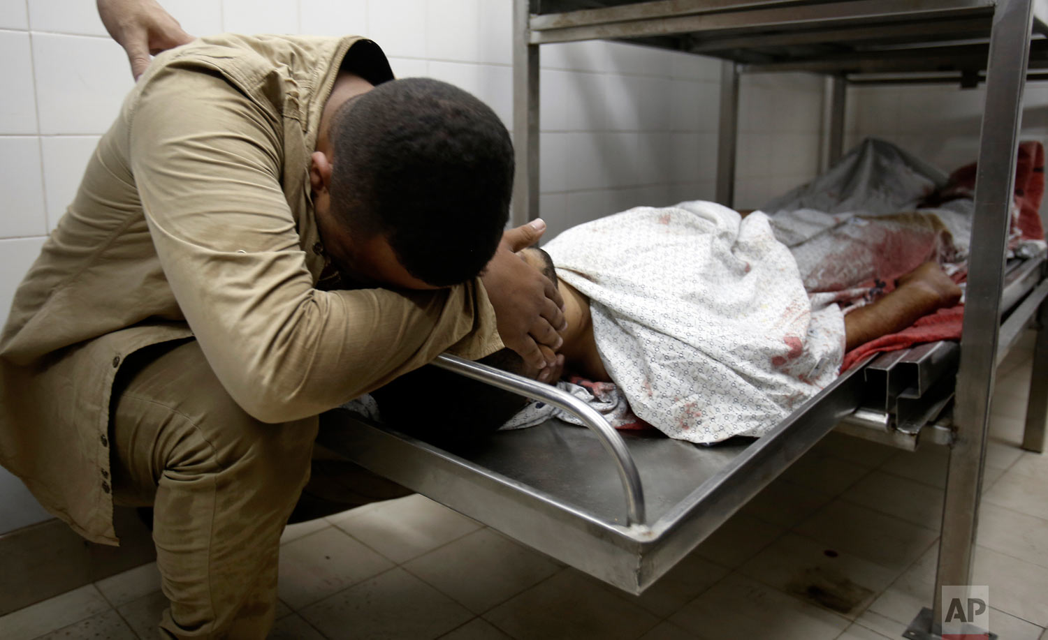 A relative mourns over the body of Abdullah al-Qutati, 26, at the morgue of the European hospital east of Khan Younis, southern Gaza Strip, east of Khan Younis, Friday, Aug. 10, 2018. Two Palestinians, including a paramedic, were shot and killed by Israeli fire at a Hamas-led protest along the border, Gaza's Health Ministry said. (AP Photo/Adel Hana) 