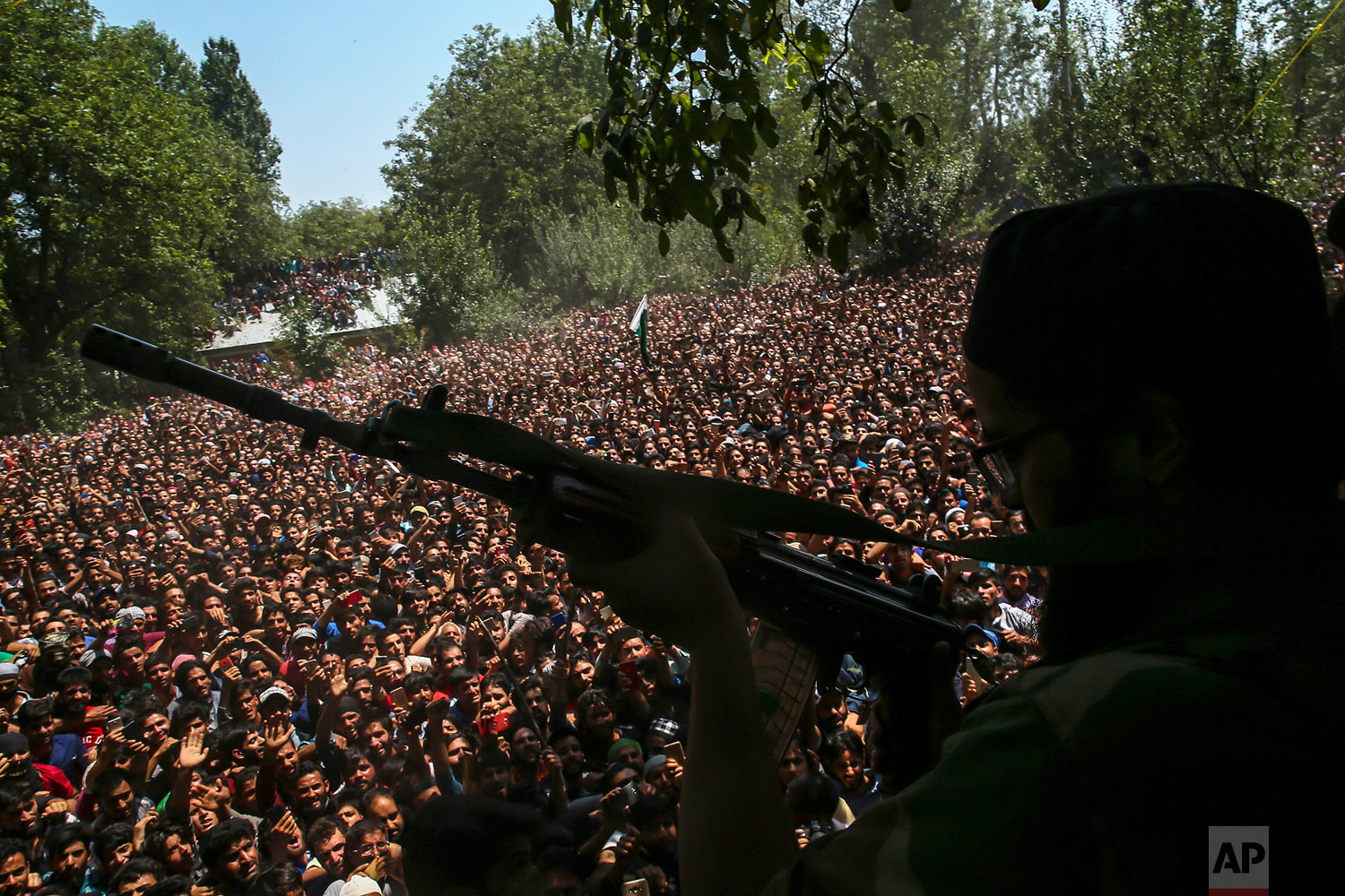  A Kashmiri rebel fires his gun to salute fallen comrades during their joint funeral in Malikgund village, south of Srinagar, Indian controlled Kashmir, Saturday, Aug. 4, 2018. At rebels and an Indian army soldier were killed in gunbattles in disputed Kashmir, triggering violent protests by residents opposed to Indian rule, officials said Saturday. (AP Photo/Dar Yasin) 