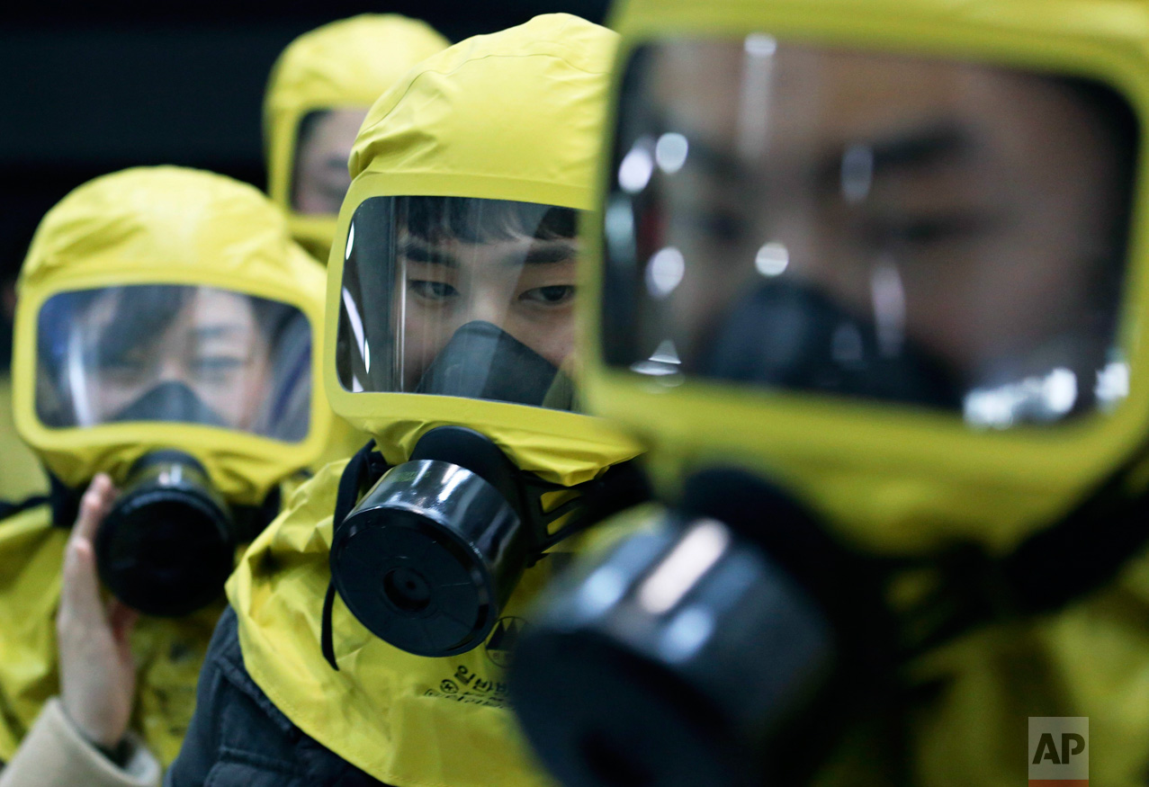 South Korean government officials wearing gas masks attend a civil defense drill against a possible North Korea's chemical attack at their office in Seoul, South Korea, Wednesday, March 15, 2017. A nationwide civil defense drill took place Wednesday preparing for possible terror, natural disaster or sudden air attack by North Korea. (AP Photo/Ahn Young-joon)
