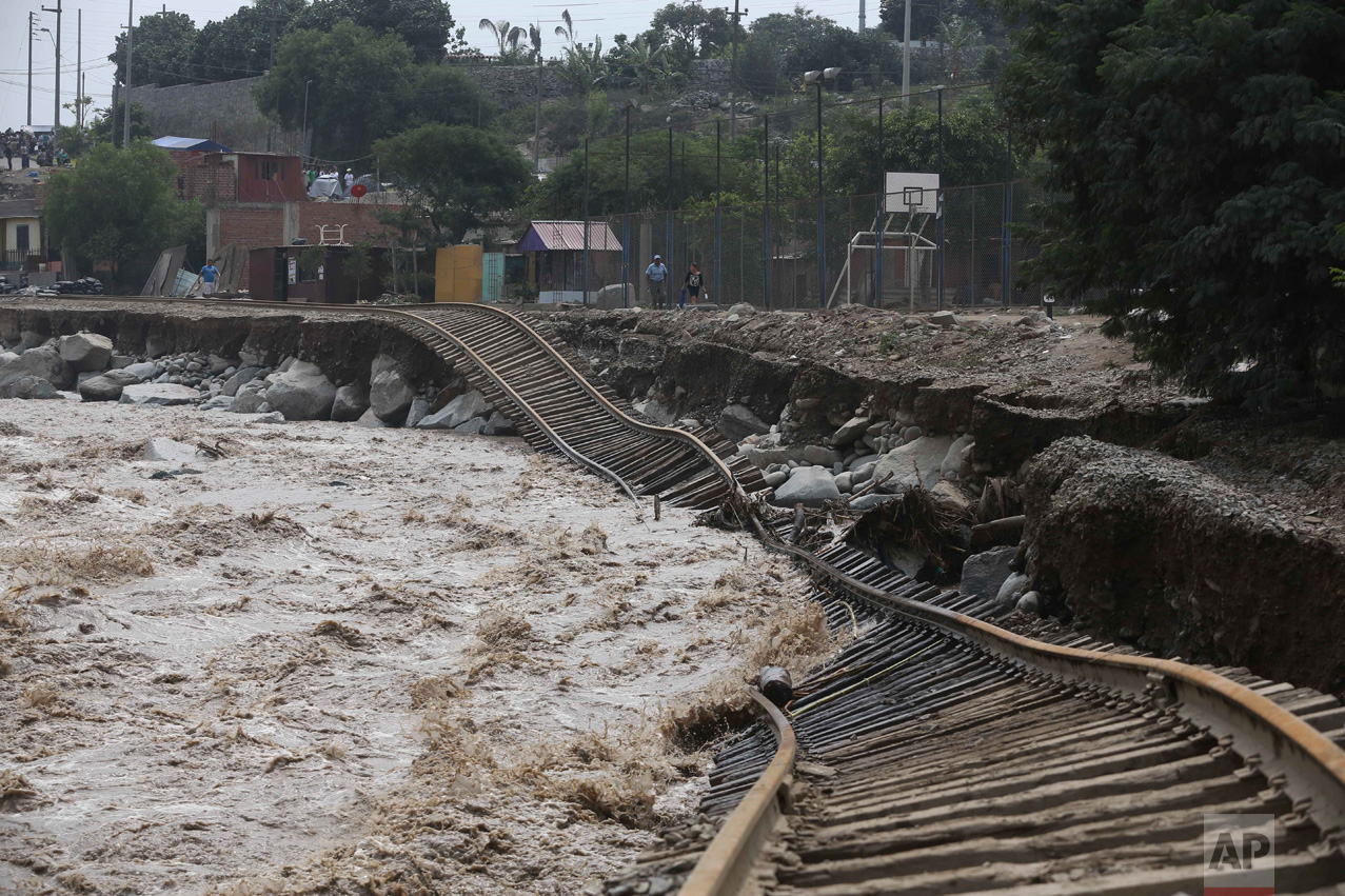 Train tracks are twisted into a flooded river in the Chosica district of Lima, Peru, on Sunday, March 19, 2017. Intense rains and mudslides have wrought havoc around the Andean nation and caught residents in Lima, a desert city of 10 million where it almost never rains, by surprise. (AP Photo/Martin Mejia)