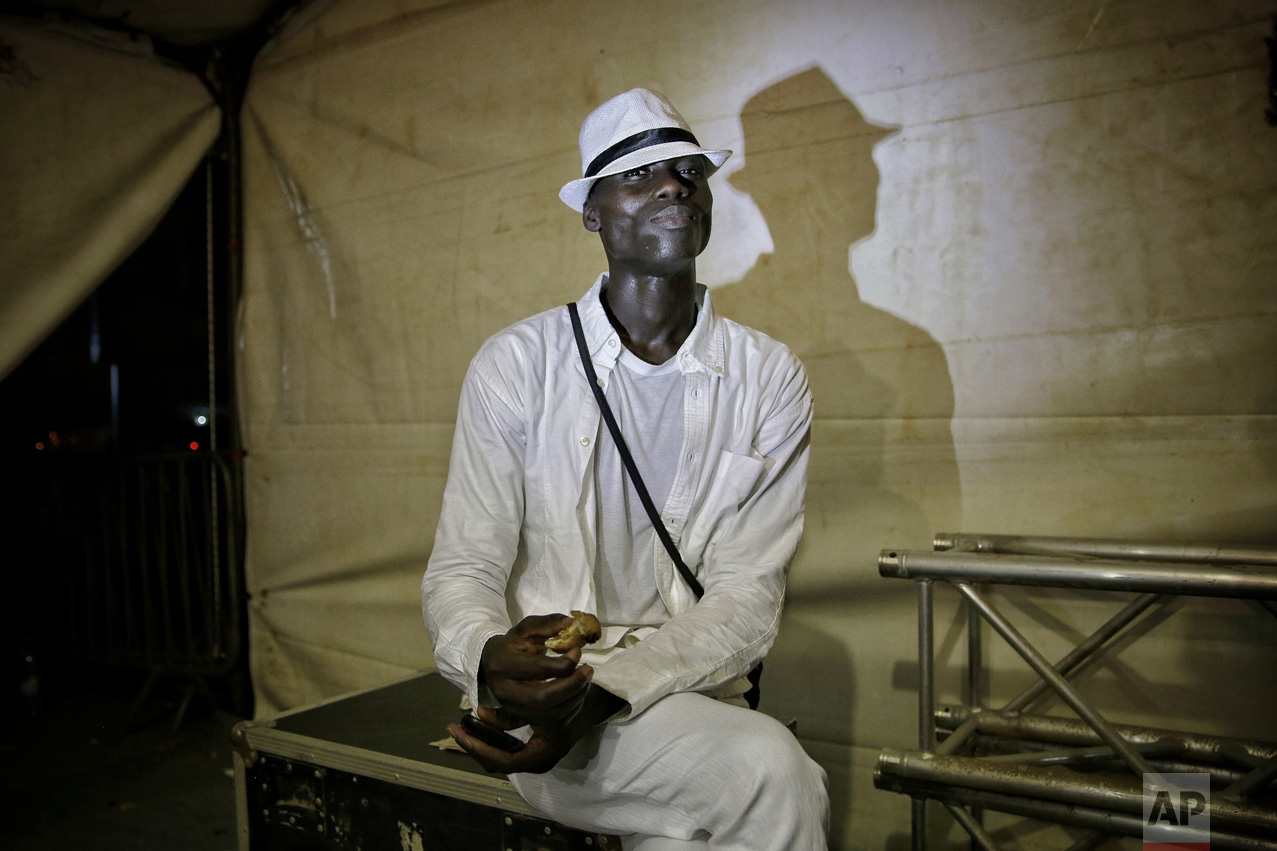 A models eats a sandwich backstage during Dakar Fashion Week in the Senegalese capital, Friday June 30, 2017. (AP Photo/Finbarr O'Reilly)