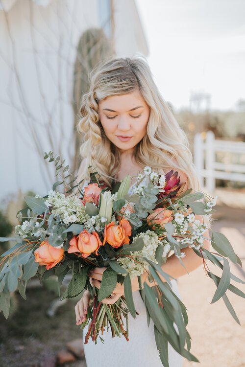 southern_wedding_flowers_botanicals_bouqet_bride_looking_at_flowers_wedding_dau_knoxville_asheville_rustic_wild_romantic