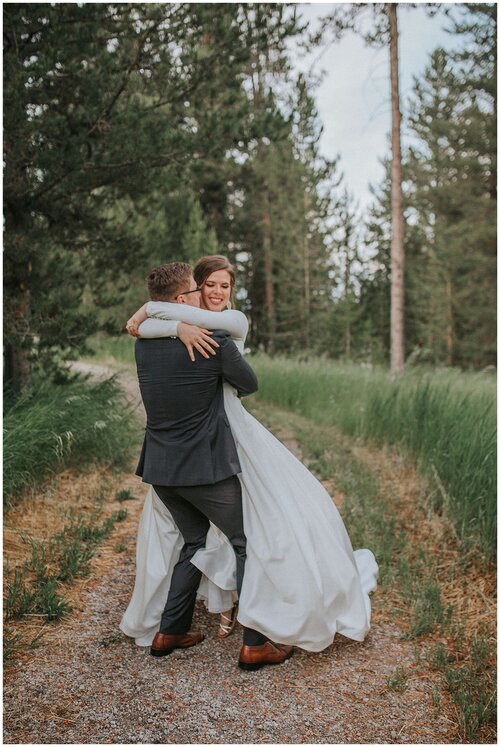 couple-hugging-while-on-a-trail-big-wedding-dress-mountains-greenery-elopement-session