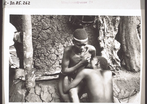 A doctor sucks blood from a sick woman. Cameroon, early 1930s.