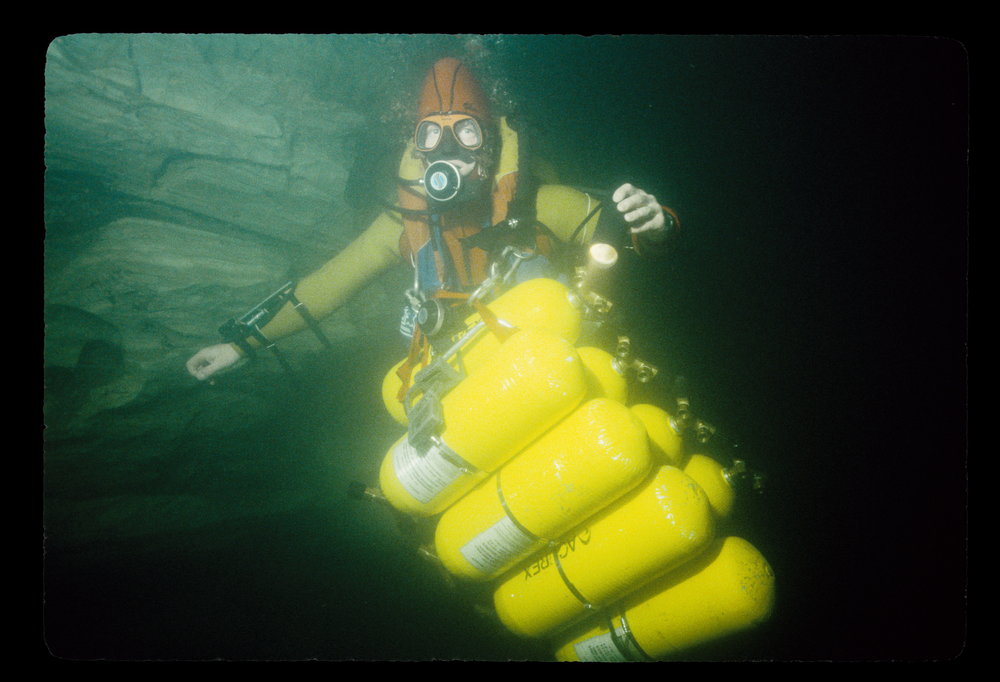Deep sea diver underwater with yellow oxygen tanks